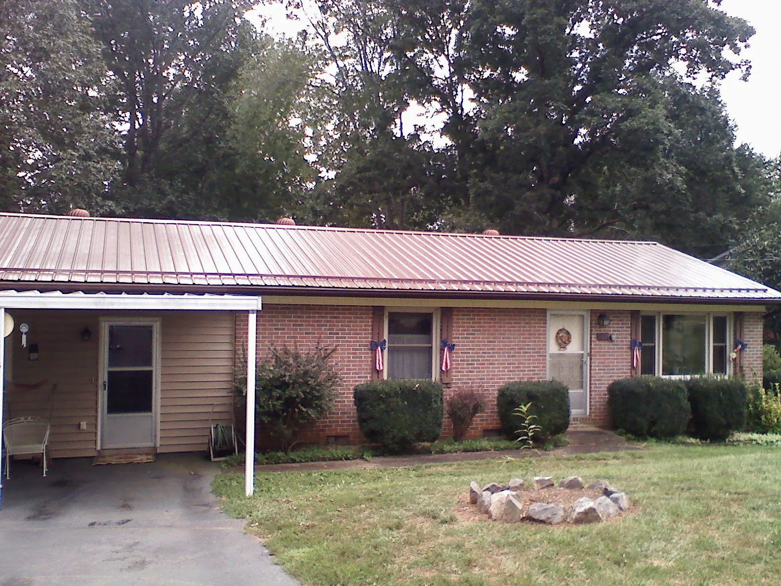 Bronze metal roof and carport on a brick ranch home — Roof Repair work by our crew in Anvik
